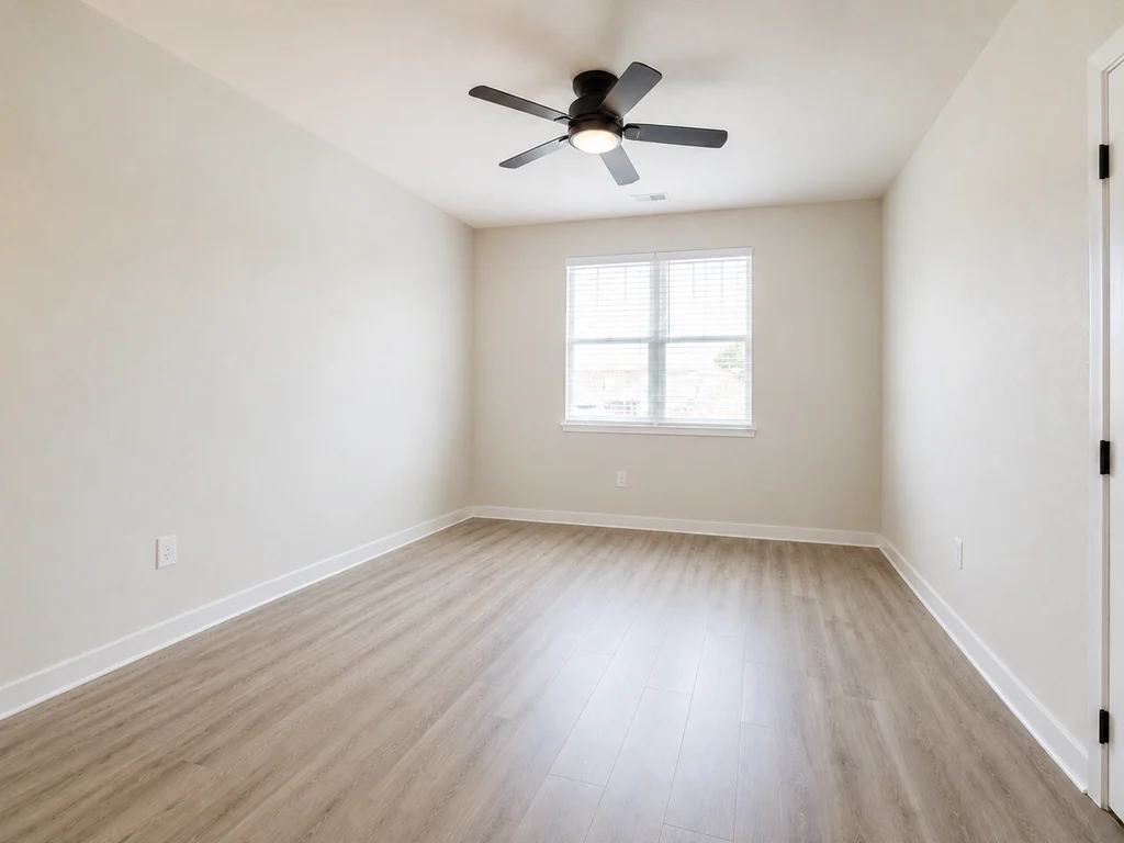 Bedroom before virtual staging: bedroom with a ceiling fan and centered window, shown empty.