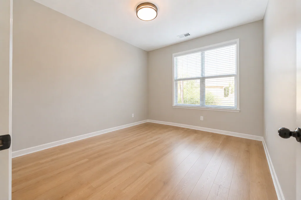 Home office before virtual staging: light room with a wide window, shown empty.