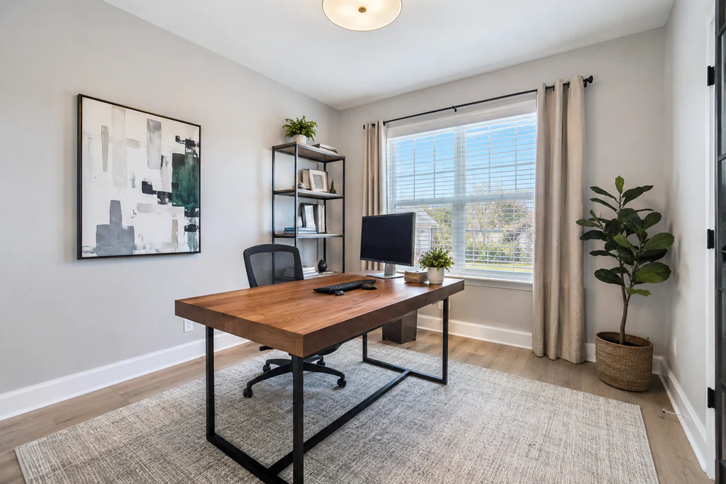 Home office after virtual staging: the same light room with a large window and blue-sky view, furnished and styled.